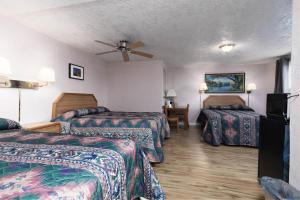 a hotel room with two beds and a ceiling fan at Marianna Inn Panguitch in Panguitch