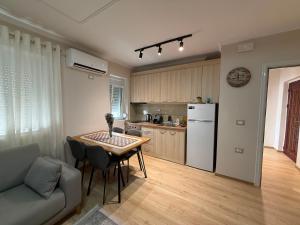 a kitchen with a table and a couch in a room at Lenci's Apartment in Berat