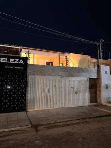 a building with a white garage door at night at Blume Suítes Premium Orla in Petrolina