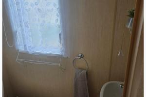 a bathroom with a shower curtain and a towel at Beautiful 8 Berth - Caravan - Abergele in Abergele +9 photos