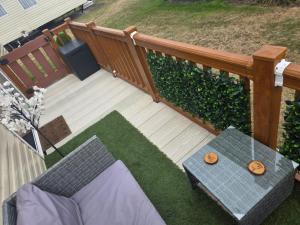 a wooden deck with a table on the grass at Beautiful 8 Berth - Caravan - Abergele in Abergele