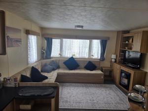 a living room with a couch with blue pillows at Beautiful 8 Berth - Caravan - Abergele in Abergele