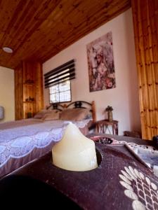 a bedroom with a bed with a hat on a table at Oak Farm مزرعة الملّول in Ajloun