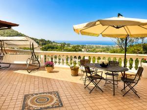 a patio with an umbrella and a table and chairs at Villa Antonietta Ischia in Forio d'Ischia