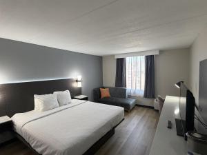 a hotel room with a bed and a chair at SureStay by Best Western Charlotte Matthews in Matthews +1 photo