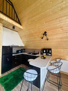 a kitchen with black cabinets and a counter with chairs at River Sound Chalet in Tba