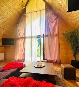 a living room with a table and a large window at River Sound Chalet in Tba