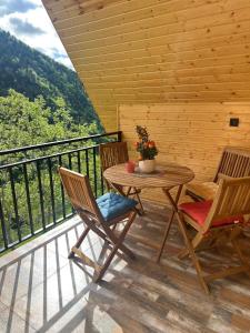 a wooden deck with a table and chairs on a balcony at River Sound Chalet in Tba +9 photos