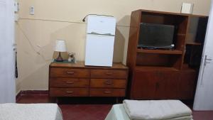 una camera da letto con un letto e una cassettiera con una TV di Lodecampu ad Asunción