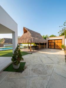 a house with a thatched roof and a patio at Guantalamera Resort in Tubará