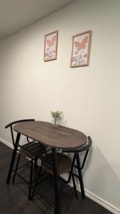 a wooden table with two pictures on a white wall at Velora Stays in Kelowna