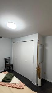 a room with a bed and a mirror and a chair at Velora Stays in Kelowna