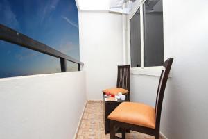 a balcony with a table and a chair and a window at Arra Grande Suites - Nearest Airport Hotels Bangalore in Devanahalli-Bangalore