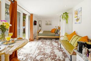 a living room with a couch and a table at Garden Studio En-Suite in Egham