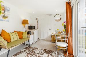 a living room with a couch and a table at Garden Studio En-Suite in Egham