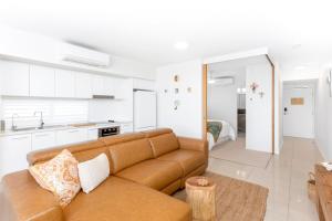 a living room with a couch and a kitchen at 'Still & Sea' in Yeppoon's CBD in Yeppoon