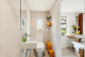 a white bathroom with a sink and a toilet at Garden Studio En-Suite in Egham