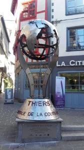 a metal sculpture in front of a building at A côté de la Gare in Thiers