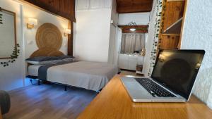 a laptop on a desk in a room with a bed at Cozy studio in medieval town in Le Val +16 photos