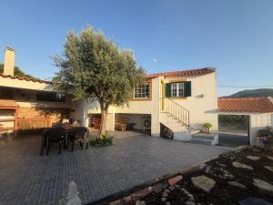 a house with a patio with a table and chairs at Casinha da Relva in Relva