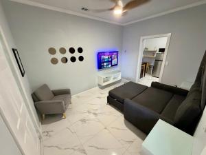 a living room with a couch and a tv at View Private Suite near LEGOLAND, Downtown & Hospital in Winter Haven
