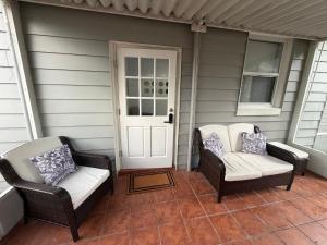 two wicker chairs sitting on the front porch of a house at View Private Suite near LEGOLAND, Downtown & Hospital in Winter Haven