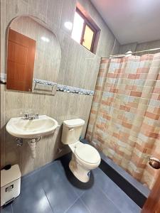 a bathroom with a toilet and a sink at "Wampu" - Amplio apartamento cerca del Centro Histórico in Cuenca +14 photos