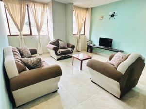 a living room with two couches and a tv at "Wampu" - Amplio apartamento cerca del Centro Histórico in Cuenca