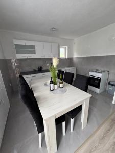a dining room table with black chairs in a kitchen at Visitor Apartment-Plav in Plav