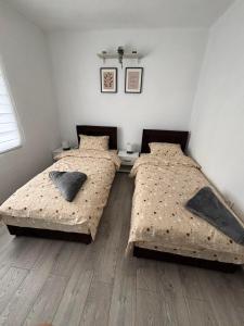 two twin beds in a bedroom with wooden floors at Visitor Apartment-Plav in Plav