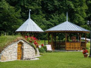 two gazebos in a park with a bench at Młyn Bosaka in Ojców