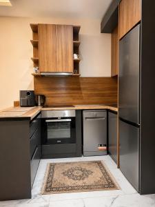 a kitchen with stainless steel appliances and wooden cabinets at Becici residance pool and sauna in Bečići