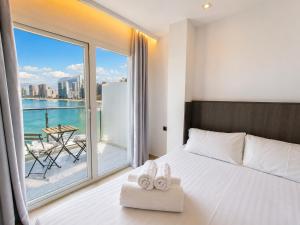 a bedroom with a bed and a balcony with a view at Hotel Bossh Lido in Benidorm +97 photos
