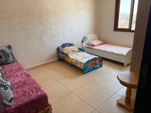 a room with two small beds and a table at Complexe luxury in Oued Laou