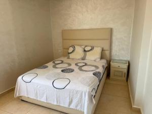 a small bedroom with a bed with white sheets and pillows at Complexe luxury in Oued Laou