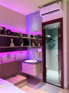 a purple bathroom with a sink and a shower at Benri Hotel Signature in Ho Chi Minh City