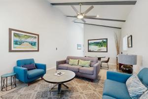 a living room with blue furniture and a ceiling fan at San Clemente - Villa Del Mar in San Clemente