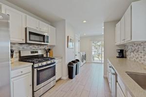 a kitchen with white cabinets and a stove top oven at San Clemente - Villa Del Mar in San Clemente
