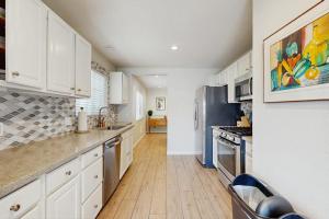 a kitchen with white cabinets and a wooden floor at San Clemente - Villa Del Mar in San Clemente +18 photos
