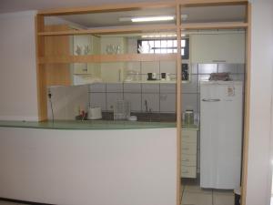  La cuisine est équipée de placards blancs et d'un réfrigérateur. dans l'établissement Porto de Iracema - Fortaleza houses, à Fortaleza