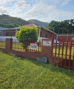 a red brick fence with afor sale sign on it at Blessed home by the Mountain surrounded macadamia in Barberton +19 photos