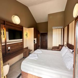 a bedroom with a large bed and a flat screen tv at Saint George Sithonia in Neos Marmaras