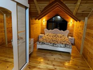 a bedroom with a bed in a wooden house at Agro Arge in Rožaje