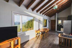 a kitchen and dining room with a table and a large window at Ave Lodge Frutillar in Frutillar