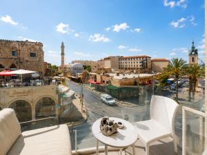 a balcony with two chairs and a table and a city at Safra - Hotel rooms in Tel Aviv