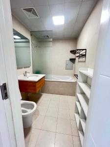a bathroom with a toilet and a sink and a tub at Mandala Garden Luxury Apartment in Ulaanbaatar