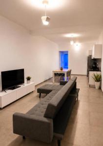 a living room with a couch and a television at Apartamento Duplex Boa Vista in Sal Rei