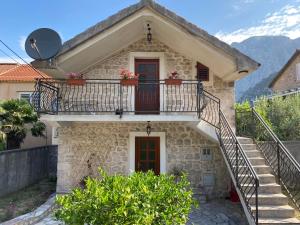 a stone house with a balcony and stairs at Charming Stone Cottage Kotor in Kotor