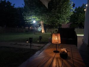 a lamp sitting on a wooden table in a yard at night at Oasi Loft in Kourouta