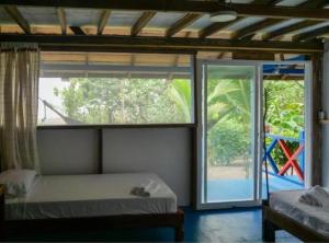 a bedroom with a window and a bed and a door at Cabañas Guaimia in Nuquí